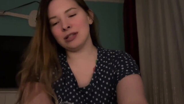 Hot brunette in polka dot top smirks seductively, natural tits tease