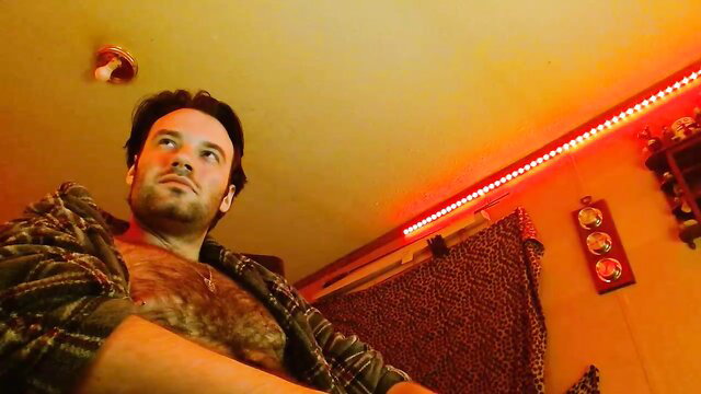 Hairy chested man in open shirt lounges seductively in gay amateur thumbnail