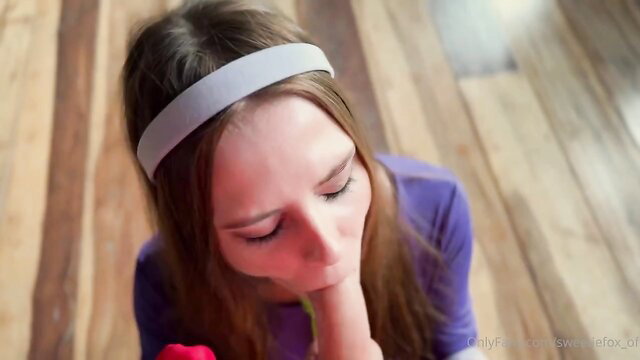 Closeup of seductive brunette with headband kissing red rose, teasing lips