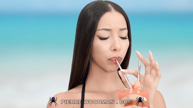 Asian babe Lia Lin sips drink in bikini at beach