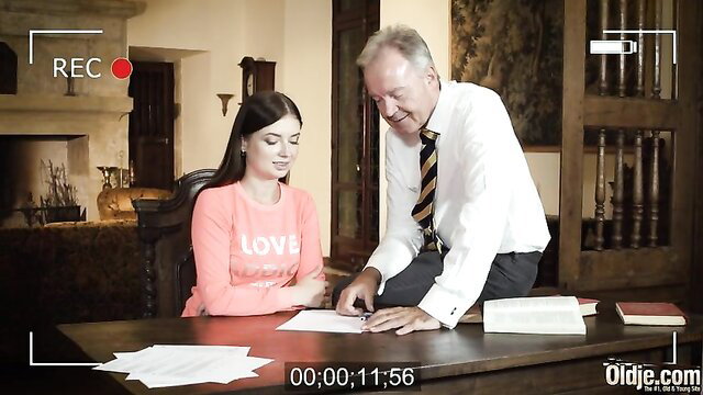 Taylor Krystal with older man at desk in pink LOVE top