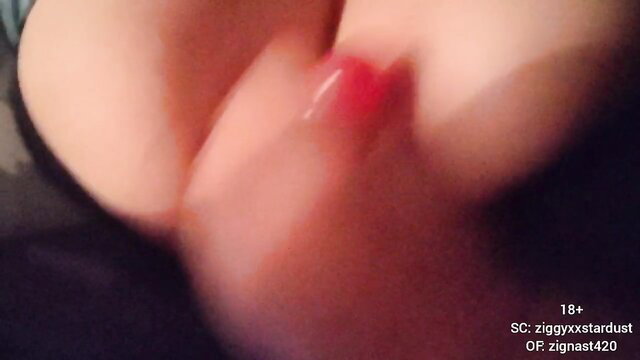 Closeup of woman's glossy red lips and huge cleavage in femdom JOI tease