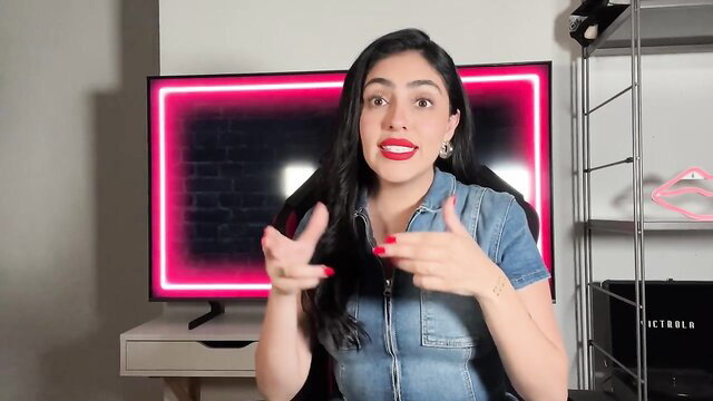 Latina with big smile gesturing hands in tight denim top, sexy pose