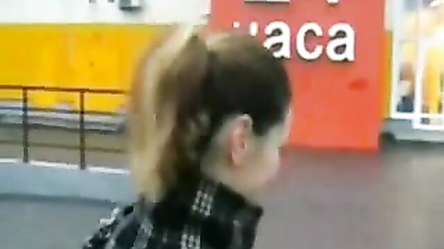 Exhibitionist woman with ponytail outside public restroom at Decathlon