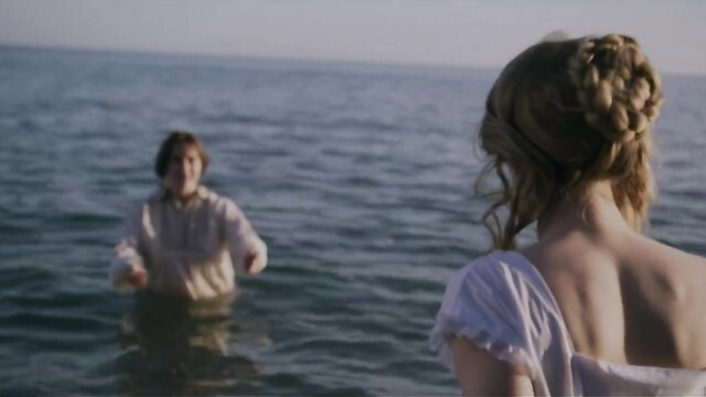 Kate Winslet in wet shirt gazing at Saoirse Ronan by sea in Ammonite nude scene