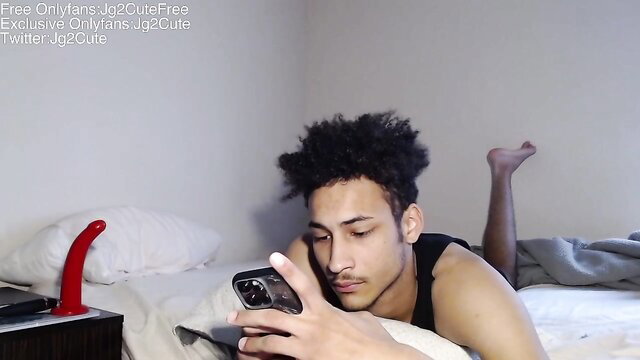 Hot mixed guy jg2cute lounging shirtless on bed with red dildo