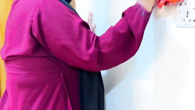 Punjabi Muslim Aunty in pink hijab reaching for wall socket