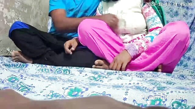 Indian couple cuddling intimately on bed, college babe in pink salwar