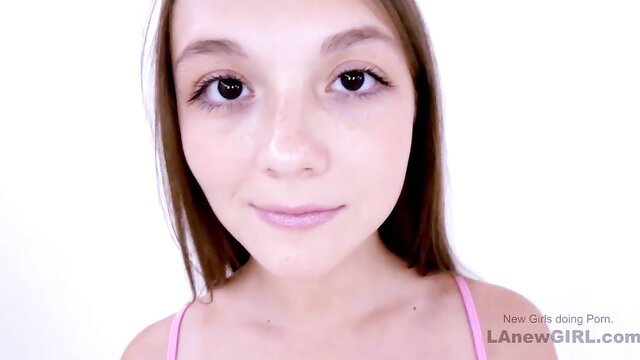 Petite cute teen girl with big eyes smiles in pink tank top