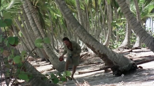 Tanned man running nude on tropical beach in erotic zombie movie celeb scene