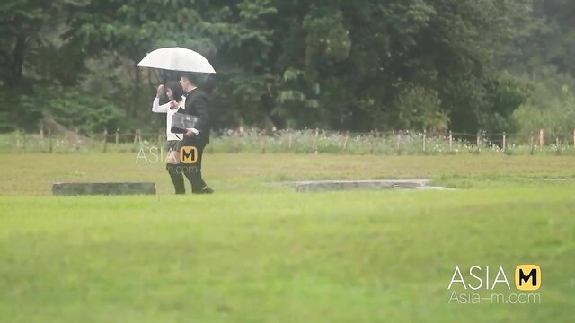Chu Meng Shu walks in white dress with man under umbrella outdoors