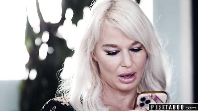 Natasha Nice with blonde hair holds phone, risks threesome