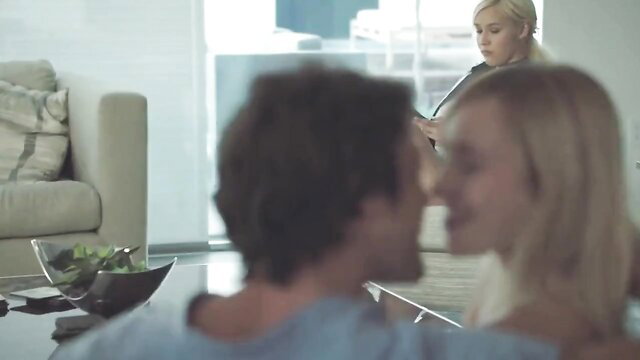 Naughty blonde teases sister's man with flirty smile on couch