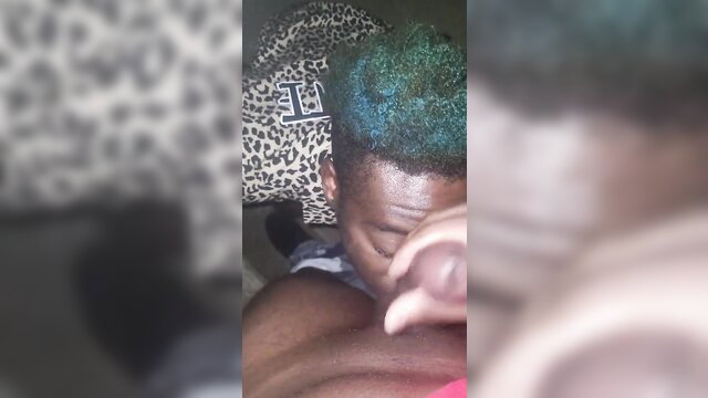 Thick black guy with green hair sucking huge cock on bleachers