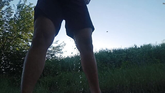 Slim boy wetting black shorts in public outdoor pee pants
