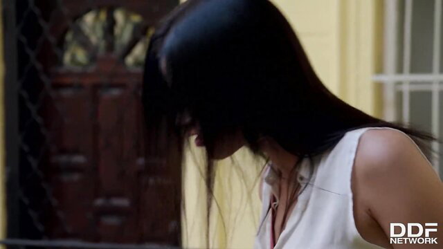 Nikky Perry in tight white top, long black hair profile view