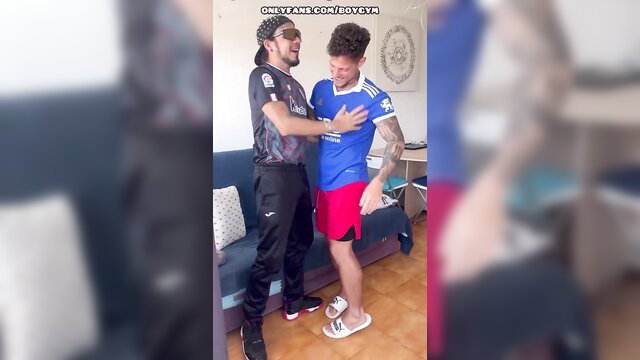 Two men embracing in a living room