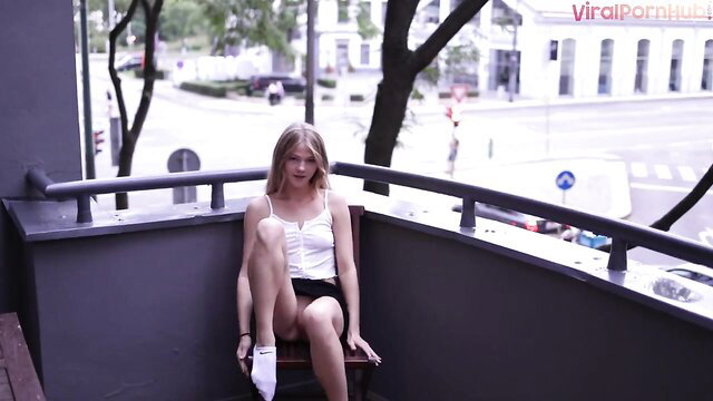 Blonde babe Diana flashes upskirt on balcony in white tank top mini skirt