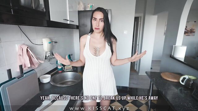 Tattooed brunette MILF in tight white dress spreads arms in kitchen tease