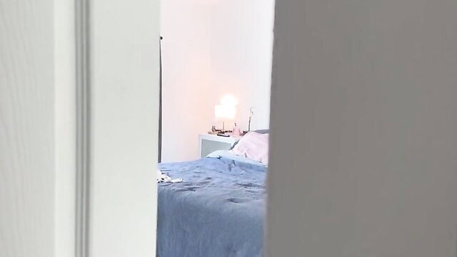 Alluring redhead teen coquette on bed in dimly lit room