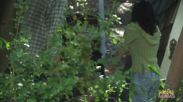 Asian couple in outdoor passion: man grabs woman in green hoodie and jeans