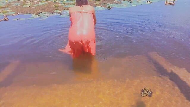 Sri Lankan sexy girl in wet red dress bathing in lotus pond