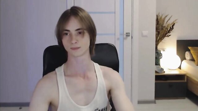 Slim toned twink in tank top sits shirtless, pale skin long brown hair