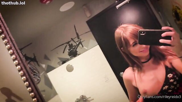Riley Reid smiling selfie in black dress choker OnlyFans bathroom