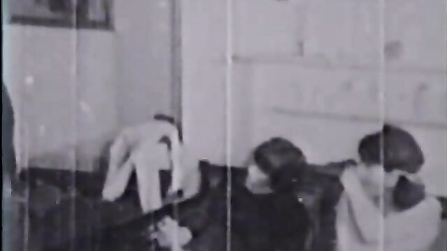 Grainy black and white image of people on a bed