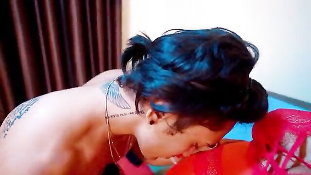 A tattooed man kissing a girl's red panties