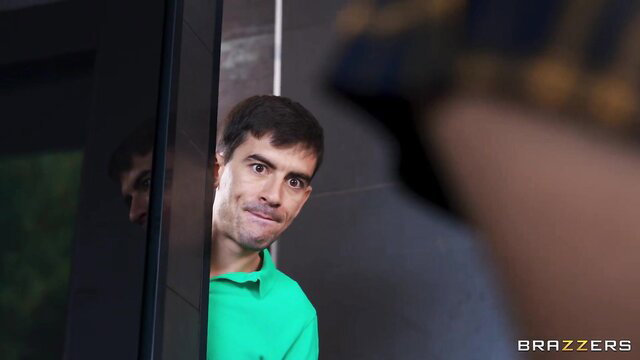 Handsome Latino man in green polo peeking through glass door in steamy encounter