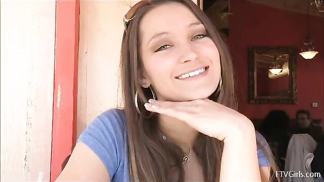 Sweet Dani smiling with hand on cheek, showing sexy tits in cafe