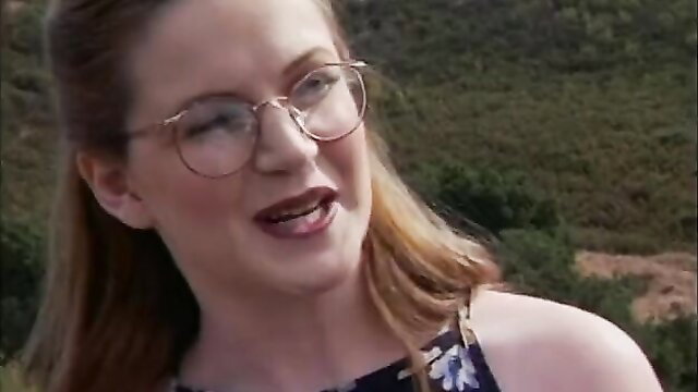 Hot brunette coed with glasses smiling outdoors in floral top