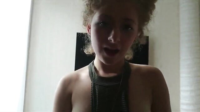 Closeup of horny curly-haired girl's open mouth and bare tits