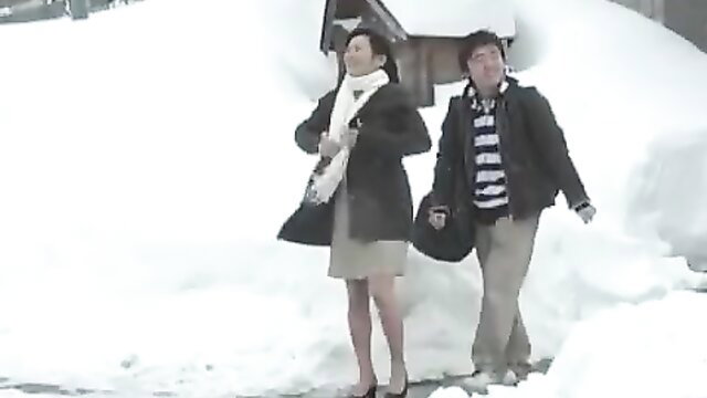 Japanese lady in skirt and scarf with man in snowy outdoor JAV scene