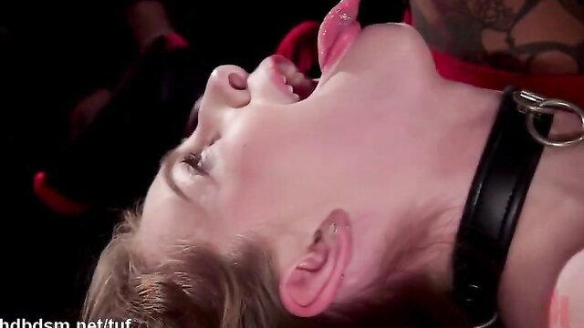 Blonde sub woman with collar tongue out in hot orgy BDSM scene