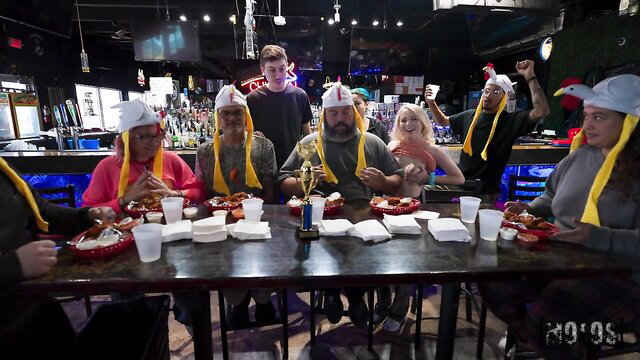 Tony Rubino and group in chicken hats eating at bar, Mofos wild affair