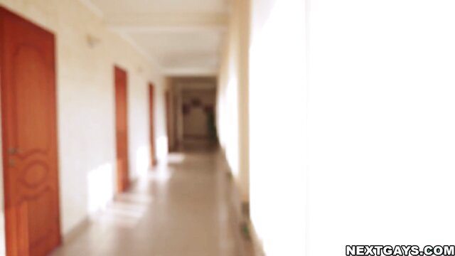 Blurry hotel hallway with red doors and sunlight, NextGays watermark