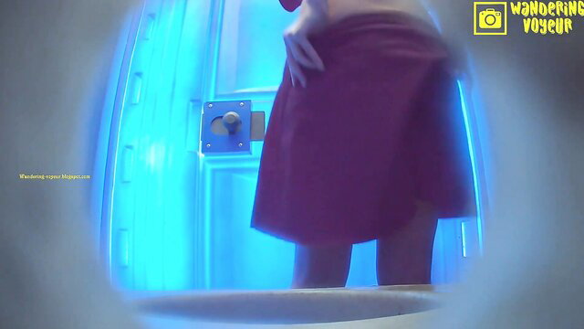 Voyeur cam spies busty woman in towel bending over in tanning booth