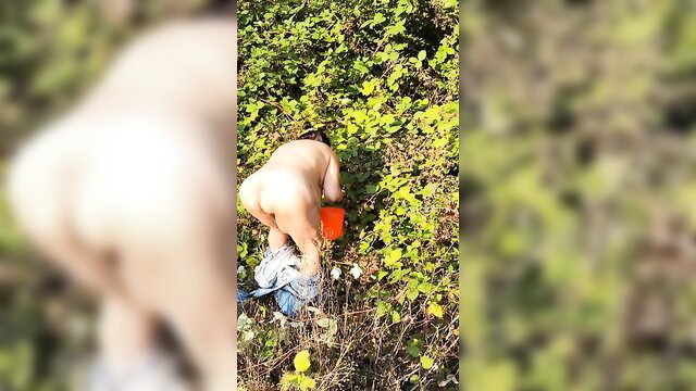 Old hairy mature woman naked peeing while picking berries outdoors