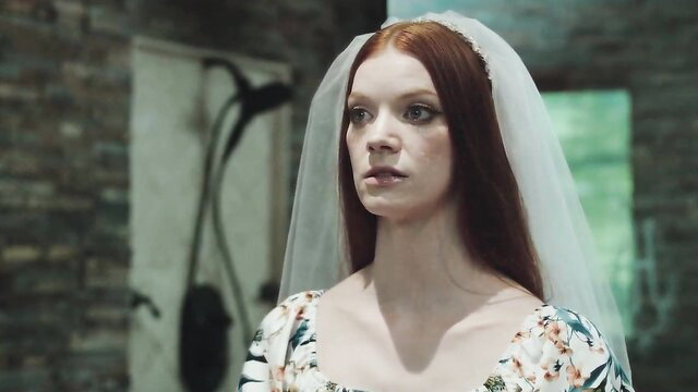 Redhead bride in sheer veil, hypnotized gaze in eerie scene