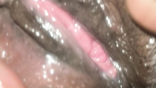 Closeup of black woman's wet shaved pussy lips spread in lesbian porn