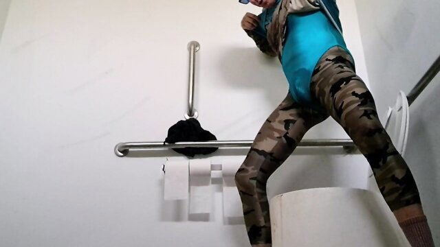 Trans in turquoise bodysuit and camo pants poses sexy in bathroom after peeing