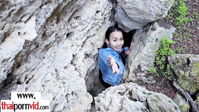 Smiling Asian Thai mom in denim jacket at cave entrance amateur porn