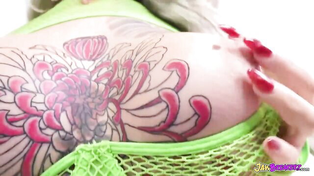 Luna Legend's pink chrysanthemum tattoo on curvy ass in green mesh top