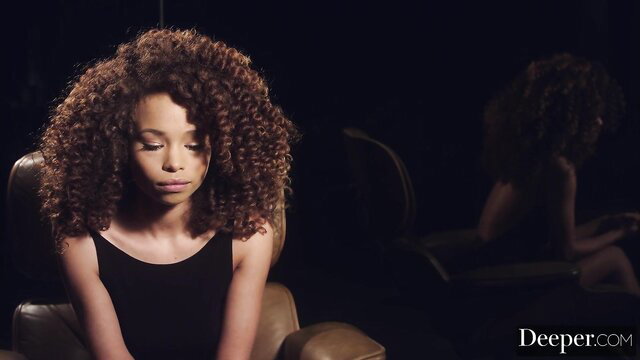 Cecilia Lion curly hair portrait in black top, sensual gaze