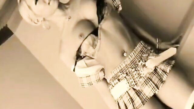 Asian blonde in sexy schoolgirl skirt, bra top, piercing navel closeup