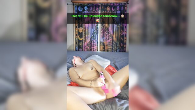 Horny MILF teases wet pussy with pink dildo on bed