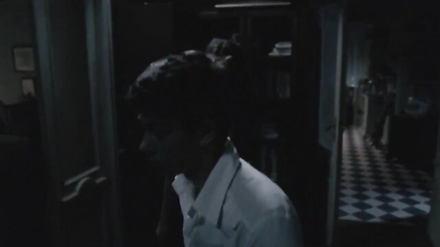 Handsome man in white shirt in dim Romanian film sex scene