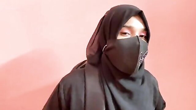 Asian hijab girl in black mask and niqab closeup, teasing eyes